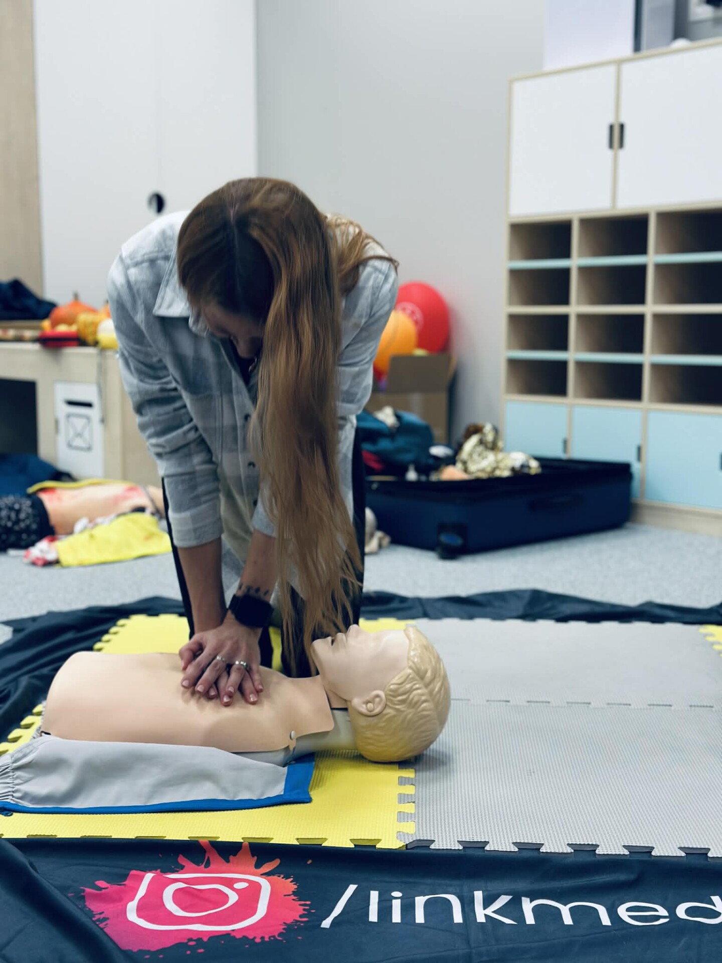 Uczestnik szkolenia ćwiczy resuscytację na fantomie QCPR